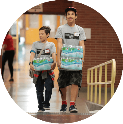 two volunteers carrying water bottles